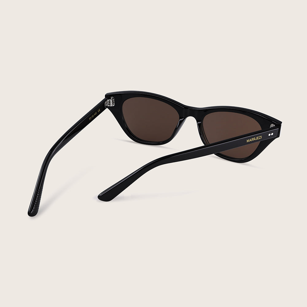 Black sunglasses with brown lenses on a beige background