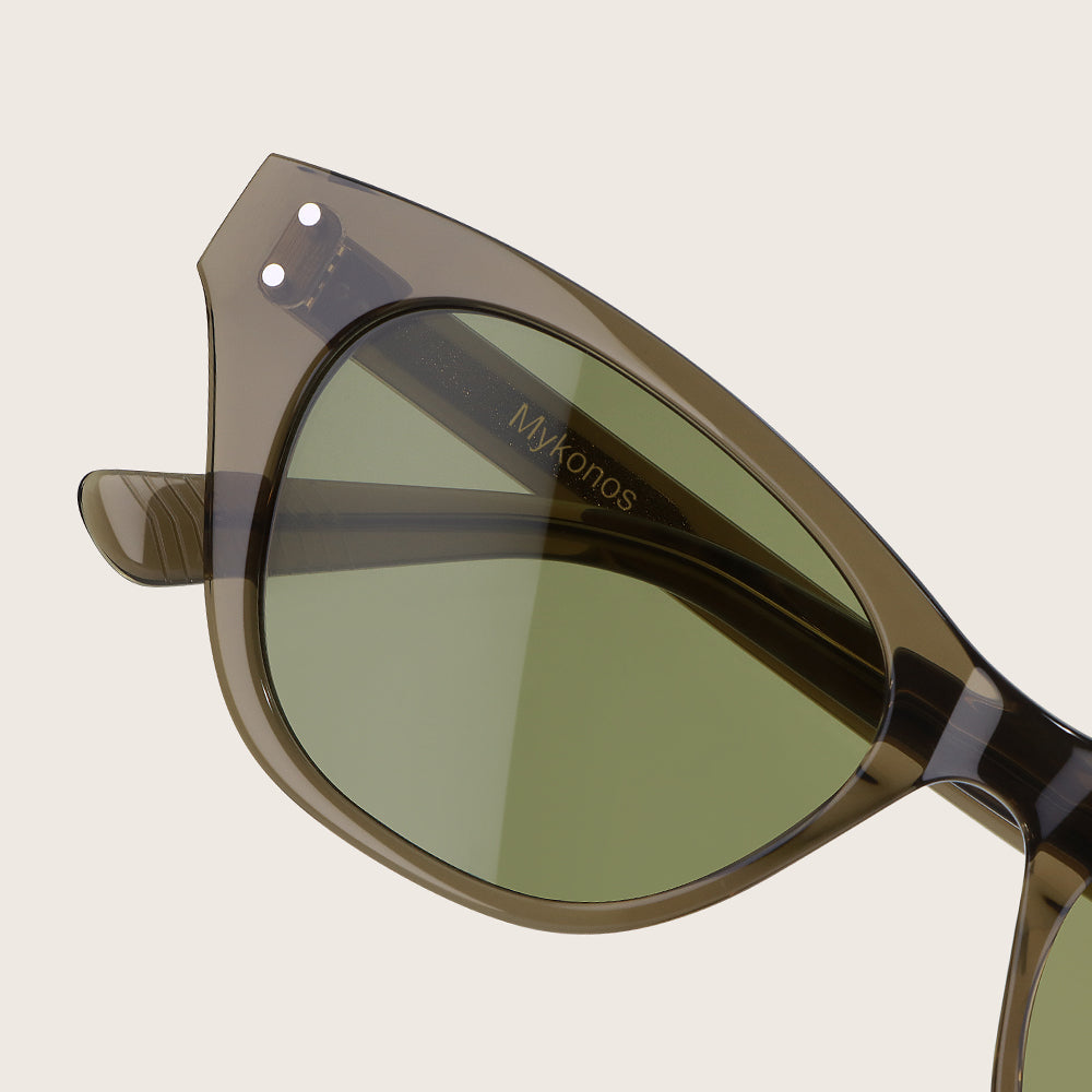 Sunglasses with green lenses and brown frame on a beige background