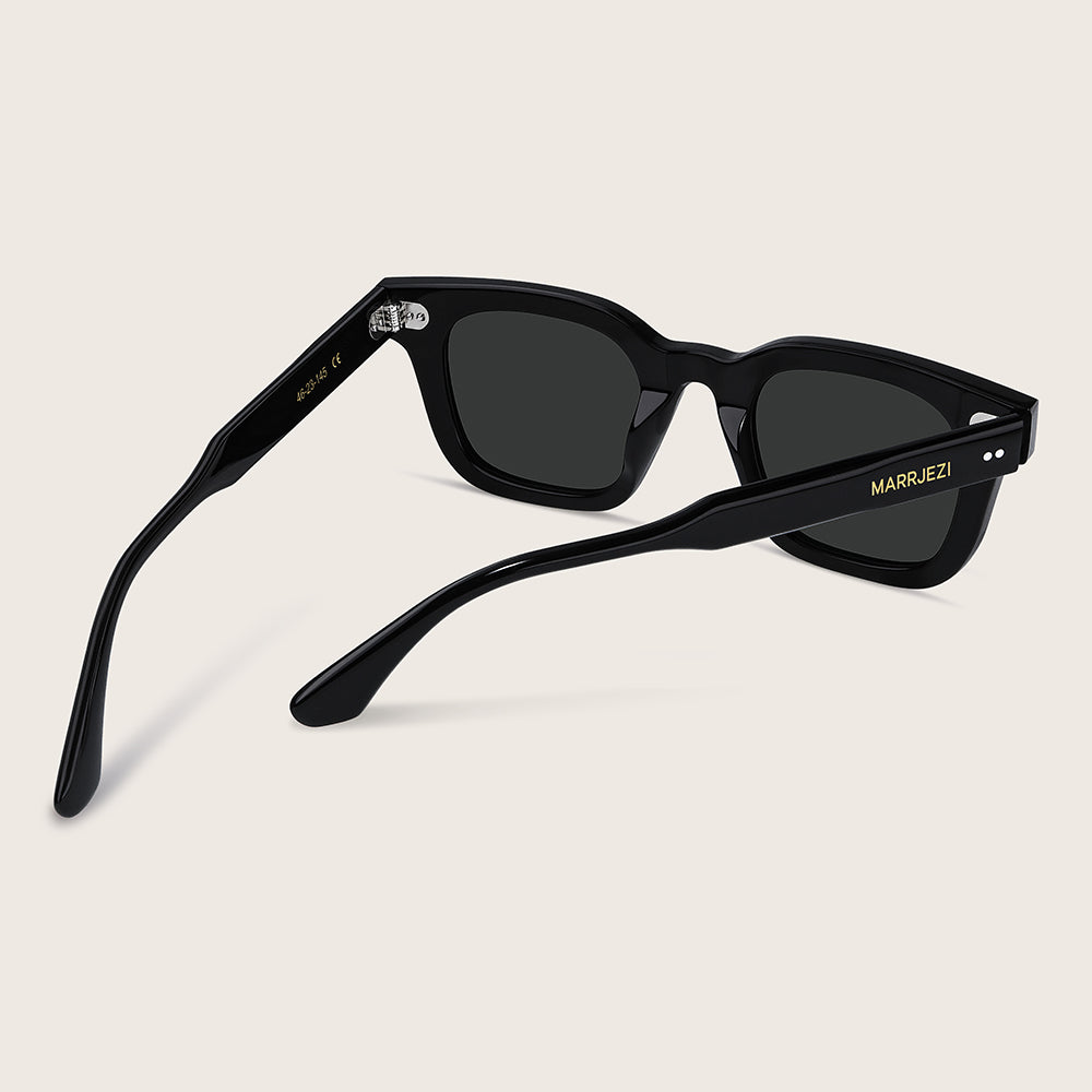 Black sunglasses with 'Marujezi' branding on a beige background