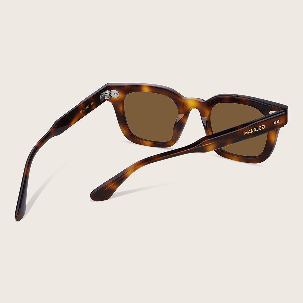 Sunglasses with tortoiseshell frame and brown lenses on a beige background
