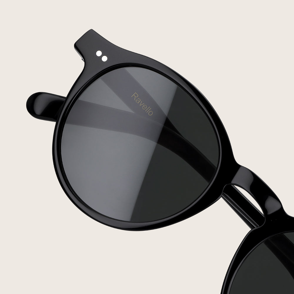 Black sunglasses with a reflective lens on a beige background