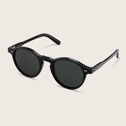 Black round sunglasses on a light beige background