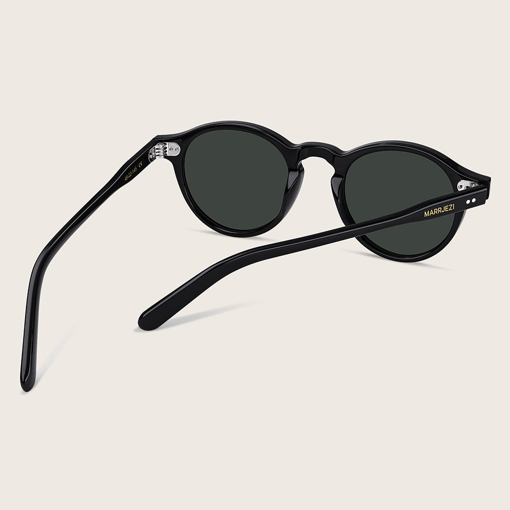 Black sunglasses with dark lenses on a beige background
