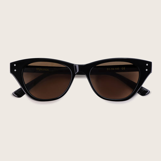 Black cat-eye sunglasses with brown lenses on a beige background