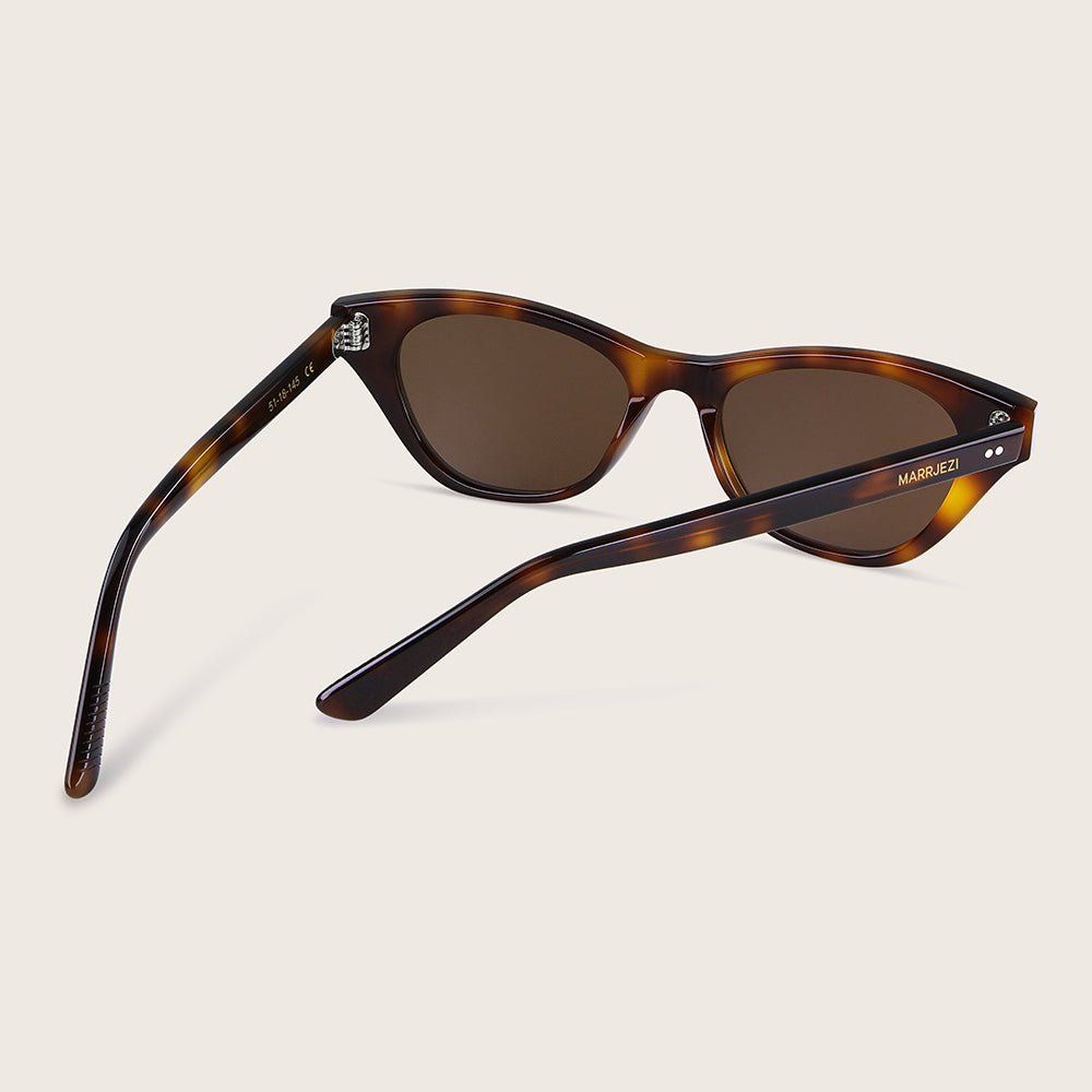 Tortoiseshell sunglasses with brown lenses on a beige background