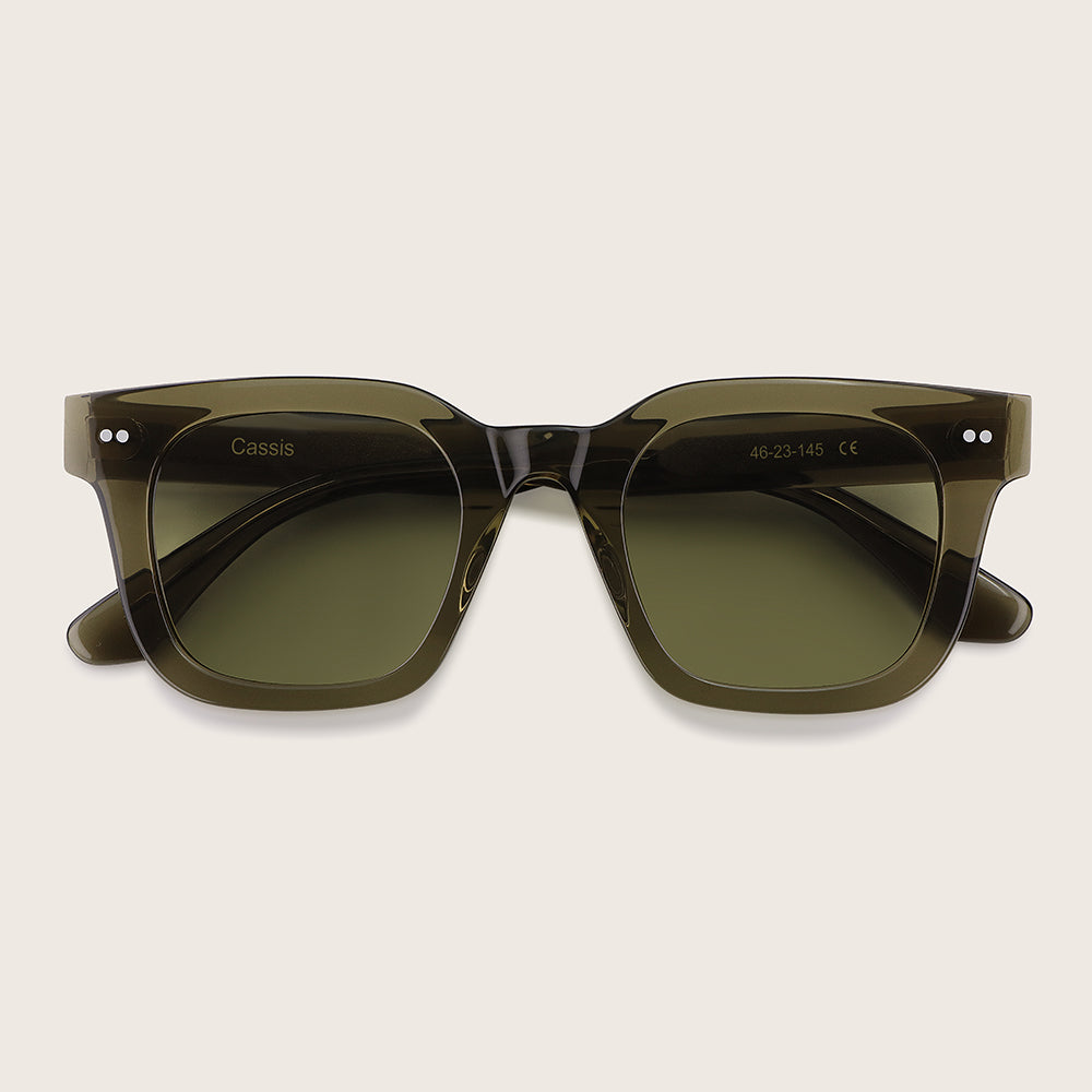 Green sunglasses with 'Cassis' branding on a light beige background