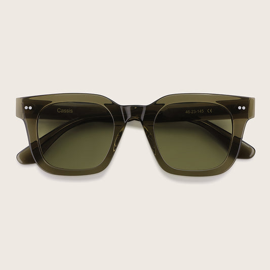 Green sunglasses with 'Cassis' branding on a light beige background