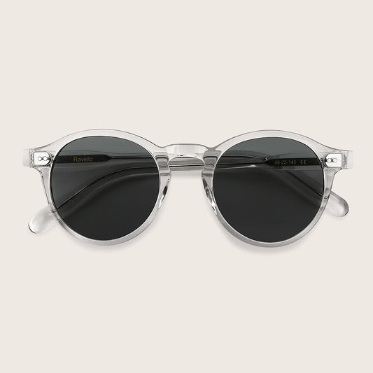 Clear frame sunglasses with dark lenses on a light beige background